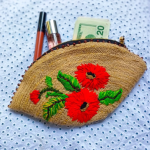 Poppy motif hand embroidered fan shaped clutch woven jute embellished with bead work.